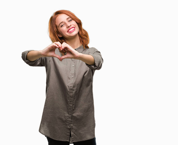 Young beautiful woman over isolated background smiling in love showing heart symbol and shape with hands. Romantic concept. - Photo, image