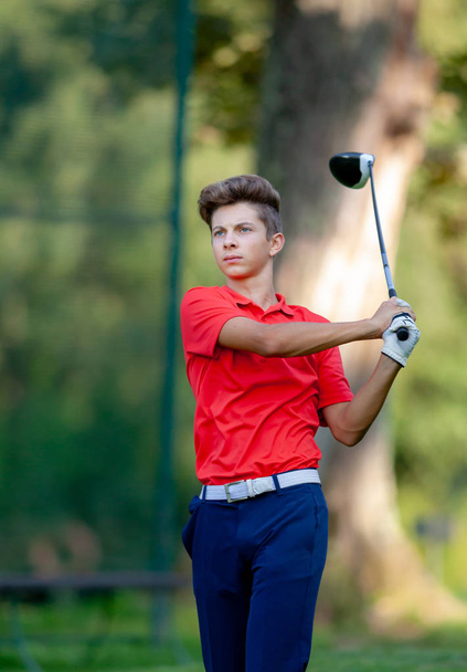 Jonge golf speler raken van de bal door hout tijdens competitie  - Foto, afbeelding