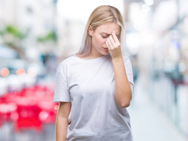 Young blonde woman over isolated background tired rubbing nose and eyes feeling fatigue and headache. Stress and frustration concept. - Photo, Image
