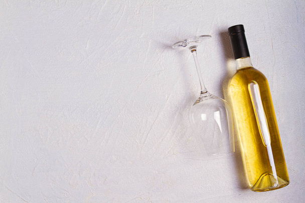 Glass and bottle of wine on white stone texture background. View from above, top studio shot - 写真・画像