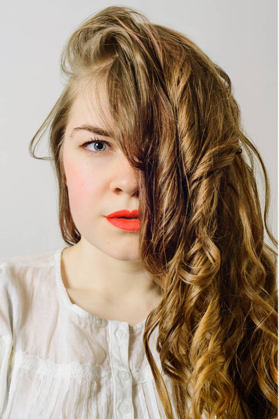 retrato de mujer joven rubia con el pelo rizado cerrado un ojo, imagen de la foto de stock
 - Foto, Imagen