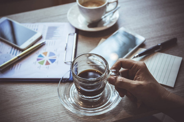 Human hand holding Black coffee and work  in coffee shop business concept - Φωτογραφία, εικόνα