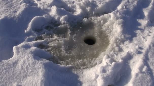 agujero de hielo para la pesca en el hielo del lago
 - Imágenes, Vídeo