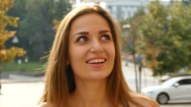 Pretty  long -hair woman in city street  walk and smiles Face close up .Slow motion, steady shot - Záběry, video