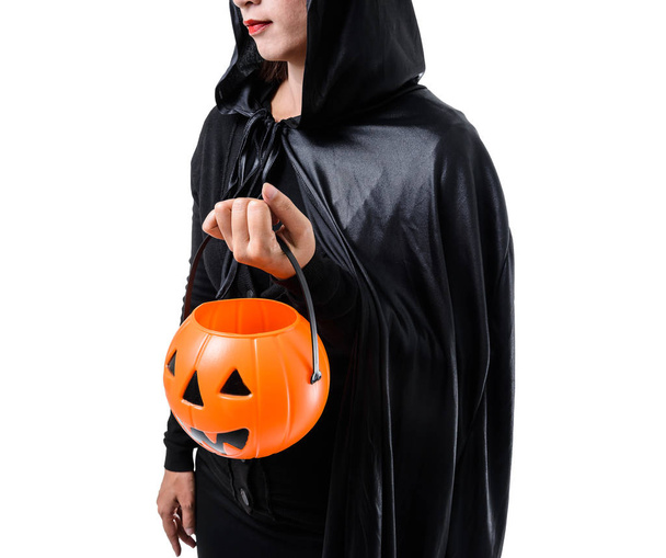 Portret kobiety w straszny czarny czarownica halloween kostium stojąc z kapelusz i przytrzymując dyni na białym tle na białym tle ze ścieżką przycinającą - Zdjęcie, obraz