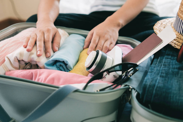 Preparazione per le vacanze o i viaggi. Imballaggio i suoi vestiti e roba in grande valigia aperta che quasi già pieno
. - Foto, immagini