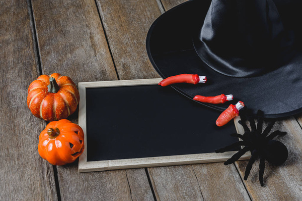 Halloween achtergrond met pompoenen, Witch hat, zwarte spin en leeg schoolbord op houten vloer. van bovenaf bekijken - Foto, afbeelding