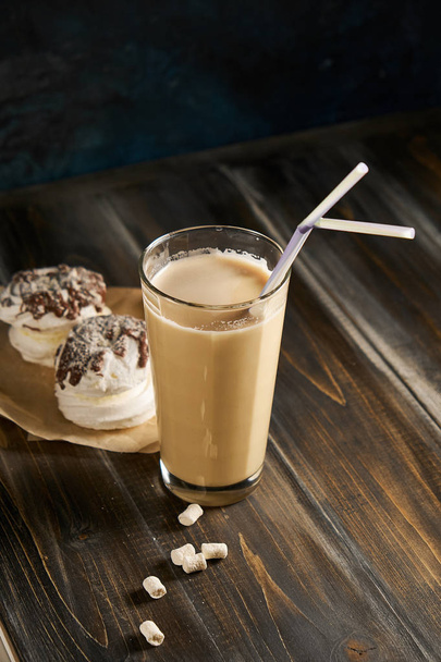 Παγωμένο καφέ σε ψηλά ποτήρια με το γάλα και καλαμάκια επί του σκάφους πάνω από αγροτική ξύλινο τραπέζι, λευκό τοίχο και κανάτα στο υπόβαθρο, διάστημα αντίγραφο. Καλοκαίρι δροσιστικό ποτό πάγου καφέ ποτό έννοια - Φωτογραφία, εικόνα