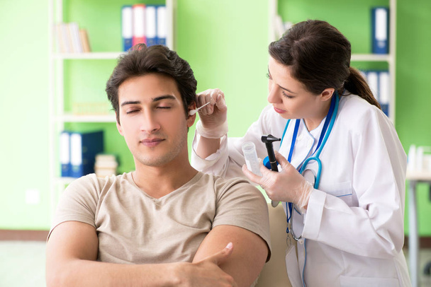 Ärztin überprüft bei ärztlicher Untersuchung das Ohr der Patienten  - Foto, Bild