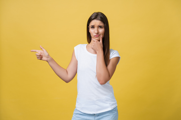 Closeup portrait of young pretty unhappy, serious woman pointing at someone as if to say you did something wrong, bad mistake isolated on yellow background. Negative emotion, facial expression feeling - Photo, Image