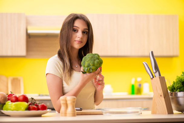 Young woman preparing salad at home in kitchen - Φωτογραφία, εικόνα