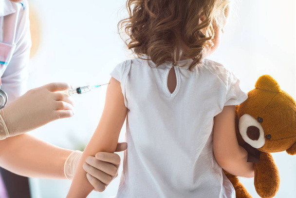 A doctor making a vaccination to a child - Foto, Bild