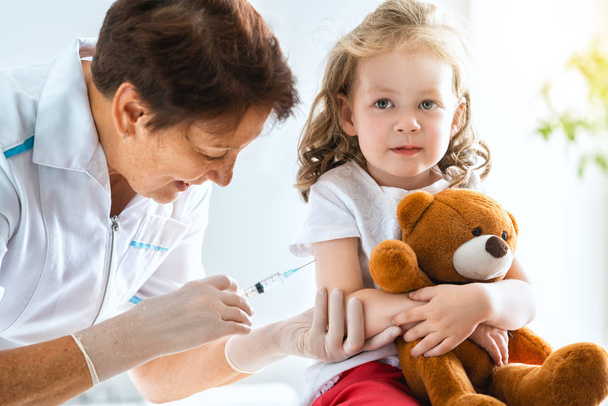 A doctor making a vaccination to a child - Foto, Bild