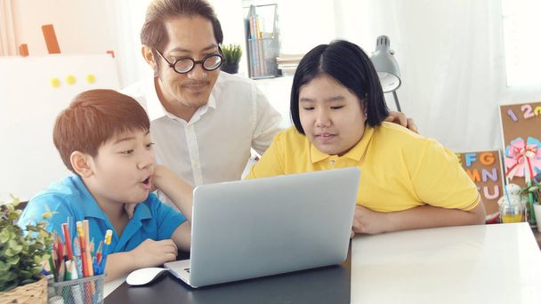 クラスの先生とラップトップ コンピューターの学習の部屋子供たちの家庭教師します。アジア子供の教師を自宅で学習. - 写真・画像