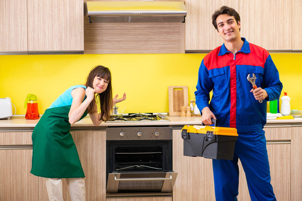 Woman with contractor at kitchen discussing repair - Photo, Image