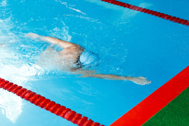 Photo of sportsman swimming in style of crawl in swimming pool - Foto, Imagen