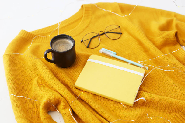 Sárga világos pulóver, Jegyzettömb, toll, szemüveg és egy csésze kávét. Őszi hangulat és a stílus. Felülnézet, lapos laikus - Fotó, kép
