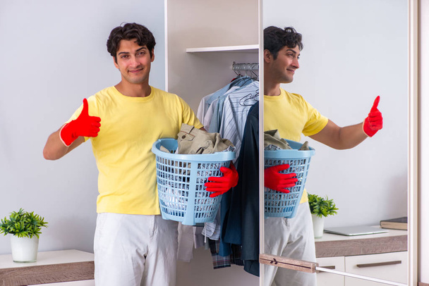 Young handsome man cleaning in the bedroom - Photo, Image
