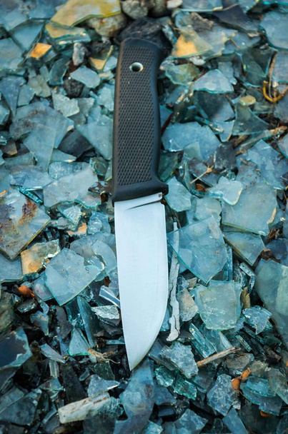 Outdoor knife. Background colorful. Glass. Vertical position. - Photo, Image