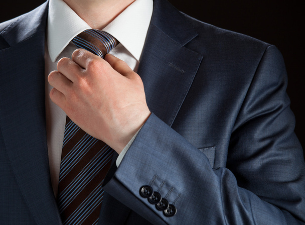 Businessman adjusting his tie - 写真・画像