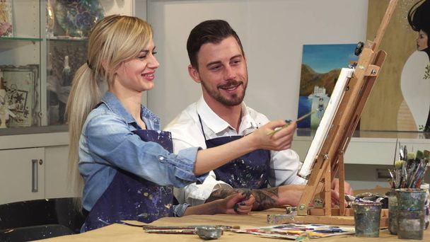 Loving young couple enjoying working on a painting at the Art Studio together - Photo, Image