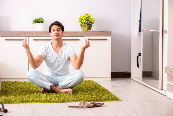 Young man doing yoga in bedroom  - Foto, Imagen