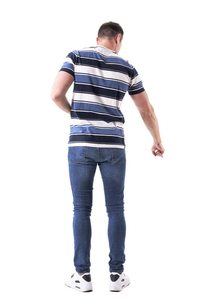 Back view of casual man pointing finger down as he found something concept. Full body isolated on white background. - Zdjęcie, obraz