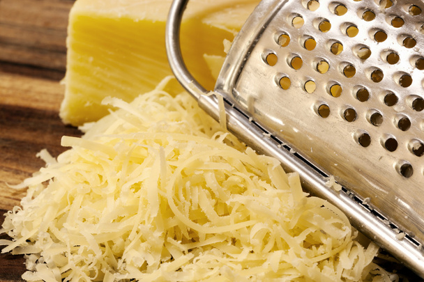geraspte kaas en rasp aan boord - Foto, afbeelding
