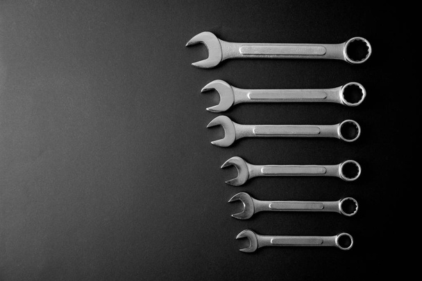 Κλειδιά σε μαύρο φόντο. Εργαλεία για επισκευή. Μαύρο και άσπρο, μονόχρωμη. - Φωτογραφία, εικόνα