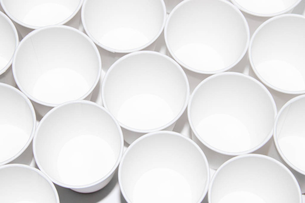 White paper cups for tea on a white background. Isolated objects. Beverages. Gently hot. Disposable tableware. Dishes for a picnic. - Photo, Image