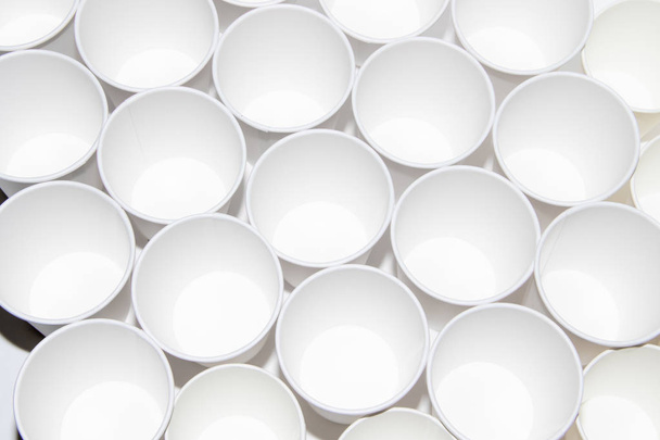 Белые бумажные чашки для чая на белом фоне. Изолированные объекты. Напитки. Нежно горячо. Одноразовая посуда. Блюда для пикника
. - Фото, изображение
