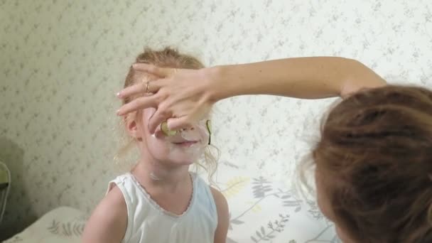 Kobieta z jej córka sprawia, że zabawa ogórek masek w domu - Materiał filmowy, wideo