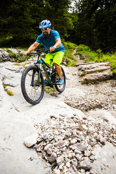 Turistipyöräily Cortina d 'Ampezzossa, upeat kalliovuoret taustalla. Mies ratsastaa MTB enduro virtaus polkua. Etelä-Tirolin maakunta, Italia, Dolomiitit
. - Valokuva, kuva