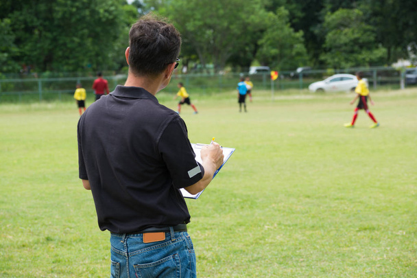 Plan de dibujo del entrenador masculino de la estrategia o del encargado del equipo o patrón de jugar al fútbol o al fútbol como diagrama en el tablero del gráfico como concepto de entrenamiento de la estrategia o del trabajo en equipo
 - Foto, Imagen