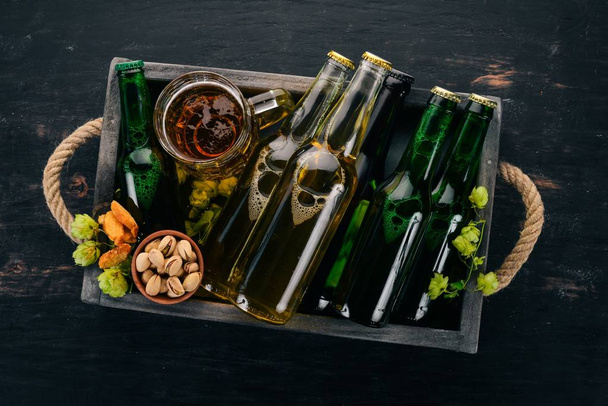 A set of beer in a wooden box. On a wooden background. Free space for text. Top view. - Фото, зображення