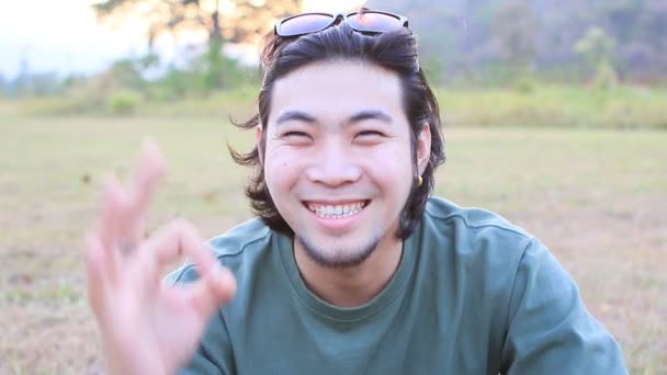 Лицо азиатского молодого человека чувствовать себя хорошо и сказать приветствие
 - Кадры, видео