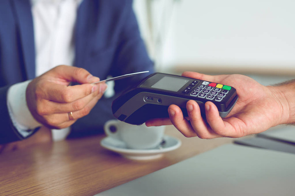 Hands of customer paying restaurant bill using credit card - Фото, зображення