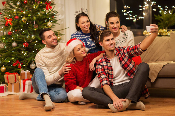friends celebrating christmas and taking selfie - Foto, imagen