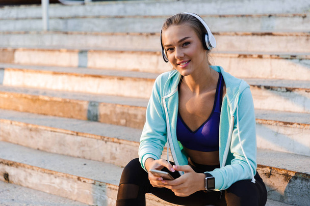 Photo of amazing young sports woman in park outdoors listening music. - Фото, зображення