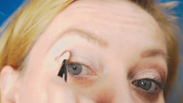 Süper yakın çekim, bir kadının onu göz makyaj yapması göz kapağı gölgeler ile boyar. 4k, ağır çekim - Video, Çekim