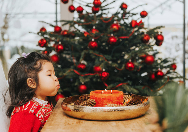 entzückendes 3-jähriges Kleinkind genießt Weihnachten, spielt mit Kerzen - Foto, Bild