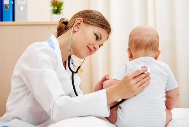 Young doctor examining baby infant with stethoscope. - Foto, Bild