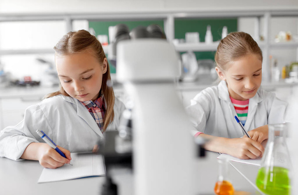 two girls studying chemistry at school laboratory - Foto, immagini