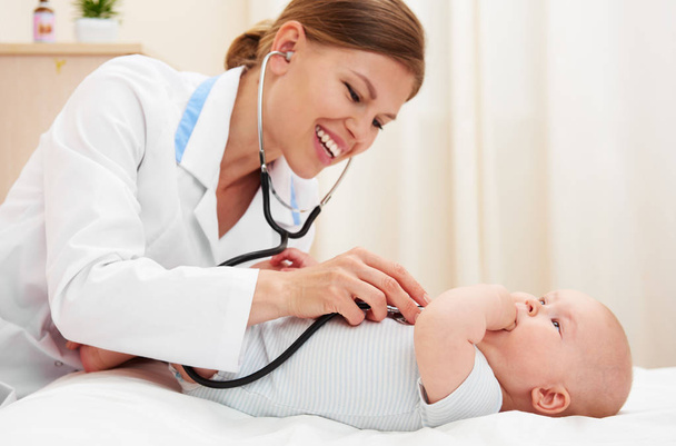 Gentle female therapist checking baby's health indoors. - Foto, Bild
