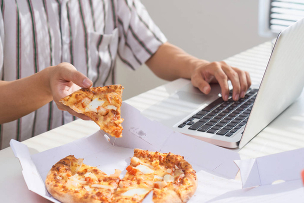 Eating pizza and social networking with a laptop. - Fotoğraf, Görsel