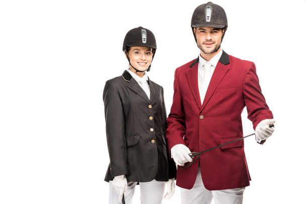 attractive young equestrians in uniform and helmets looking at camera isolated on white - Photo, Image