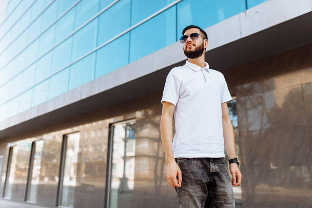 Stylish hipster in white shirt in the background of the glass building - Fotoğraf, Görsel