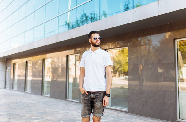 Stylish hipster in white shirt in the background of the glass building - Foto, imagen