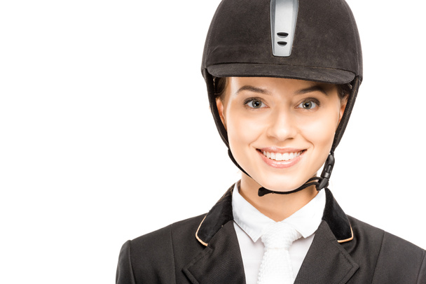 close-up portrait of happy young horsewoman in helmet looking at camera isolated on white - Photo, Image
