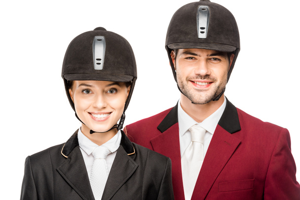 close-up portrait of smiling young equestrians in uniform and helmets looking at camera isolated on white - Photo, Image
